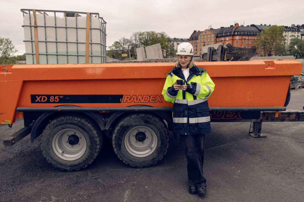 Arbeider bruker nettbrett for å overvåke maskin på byggeplass.